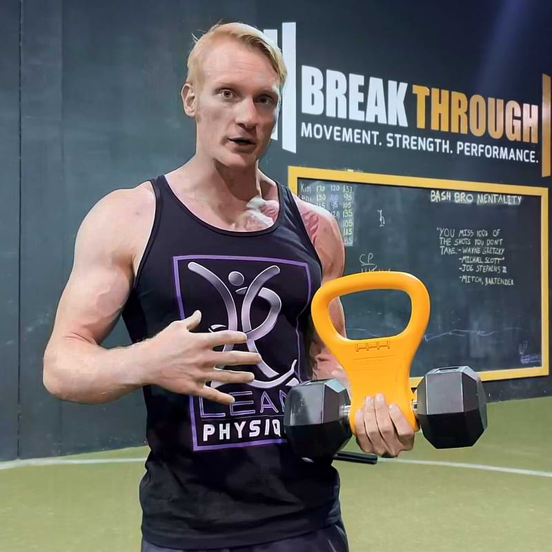 Trainer John K with orange Kettle Gryp and dumbbell